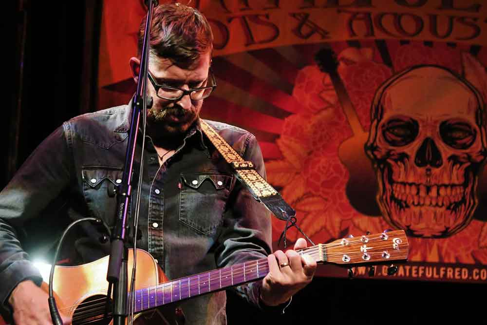 Jim Pearson on stage with acoustic guitar
